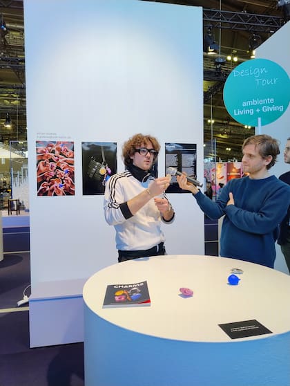 Adrian Grabow (izq.) explica las propiedades de cada modelo que integra la serie "Charms", hechos en distintos materiales (resinas, cerámica, acero inoxidable) según qué efecto sensorial busquen lograr