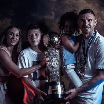 Adrián Martínez, junto con su familia, mostrando el trofeo conquistado en su paso por Libertad de Paraguay