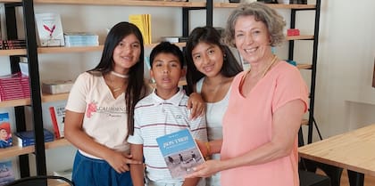 Adriana y sus hijos 3 sosteniendo el libro que cuenta su aventura de mamá por adopción.