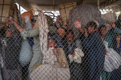 Adultos con niños se apresura a cruzar la puerta fronteriza a Pakistán desde la frontera con Afganistán en Spin Boldak el 25 de septiembre de 2021
