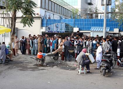 Afganos hacen fila para tratar de retirar dinero frente a un banco de Kabul, Afganistán, el lunes 30 de agosto de 2021
