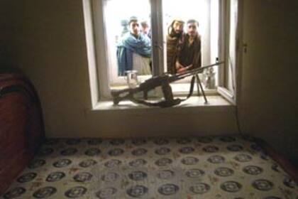 Afganos observan a través de la ventana de la ex casa del mullah Omar, en Kandahar