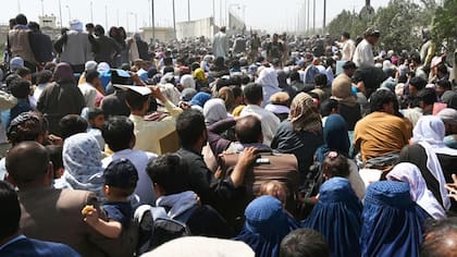 Afganos se congregan en una carretera cerca de la parte militar del aeropuerto de Kabul el 20 de agosto.