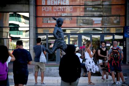 Aficionados se fotografían junto a la estatua de Eusebio frente al estadio Luz de Lisboa