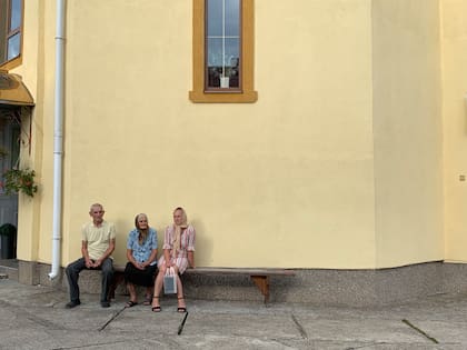 Afuera de la iglesia, la gente mayor se reúne media hora antes de que comience la misa