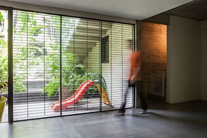 Afuera, tobogán para chicos y grandes maceteros