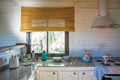 En la cocina, agarraderas tejidas a crochet, repasadores, pava enlozada y cafetera Volturno vintage de porcelana (todo de Don Terrenal).