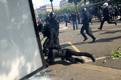 Agentes antidisturbios detienen a un joven durante una manifestación, el lunes 1 de mayo de 2023 en París