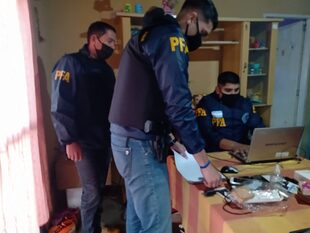 Agentes de la PFA registran datos del operativo mientras se realiza un allanamiento