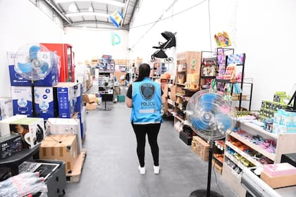 Agentes de la Policía de la Ciudad dentro del depósito de Villa General Mitre donde se acopiaban artículos de electrónica, bazar y perfumería