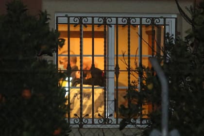 Agentes de la policía revisan el interior de la vivienda donde se produjeron los crímenes, en el municipio de Elche