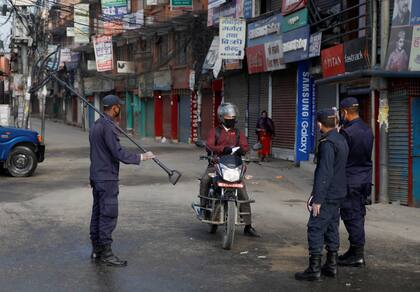 Agentes de policía de Nepal interrogan a un motociclista