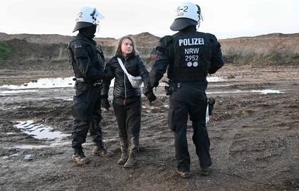 Agentes de policía retienen a la activista climática sueca Greta Thunberg entre un grupo de manifestantes y activistas en Erkelenz, al oeste de Alemania, el 17 de enero de 2023.