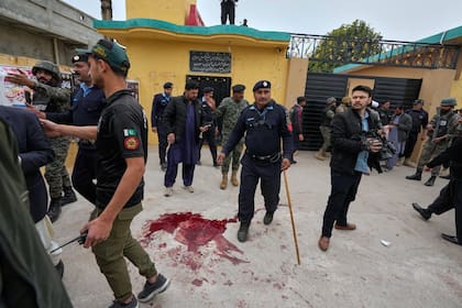 Agentes de seguridad paquistaníes mantienen alejada a la gente del lugar de la explosión de una bomba en una mezquita chiíta en Islamabad