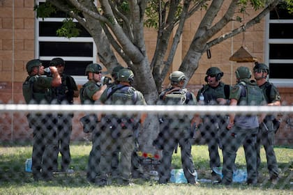 Agentes del orden parados afuera de la Escuela Primaria Robb tras el tiroteo fatal el 24 de mayo 