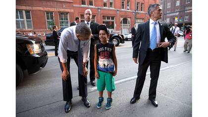 Agentes del Servicio Secreto de Estados Unidos acompañan al Presidente Barack Obama mientras saluda a un joven en la calle en Denver, Colorado, el 8 de julio de 2014.