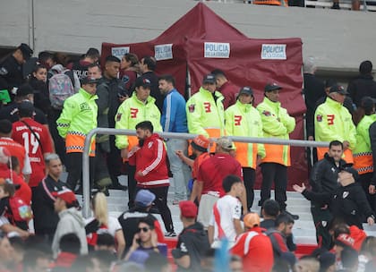 Agentes policiales y empleados de seguridad resguardan la zona donde falleció un espectador, al caer desde la tribuna durante el partido de River Plate contra Defensa y Justicia en Buenos Aires, el sábado 3 de junio de 2023 (AP Foto/Nicolas Aboaf)
