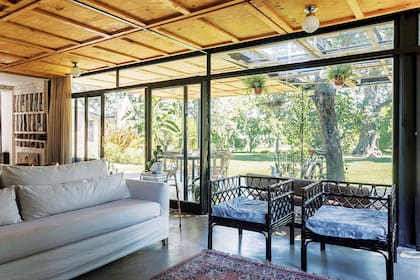 Agostina encontró estos sillones por casualidad e intuyó su potencial. Los pintó de negro y quedaron perfectamente adaptados a la propuesta. A la izquierda asoma el lugar de guardado en ladrillo de la cocina.