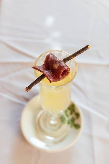 Agüita de manzanilla como trago de bienvenida acompañado de salame de llama artesanal.