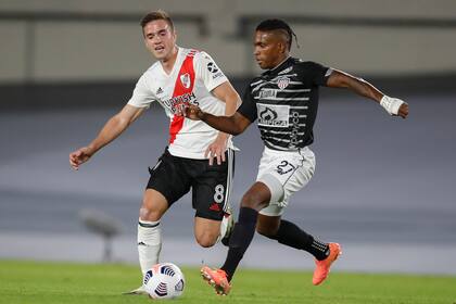 Agustín Palavecino, otro de los refuerzos, y Fabián Víáfara en puja; la historia pudo ser otra si a River lo hubieran sancionado con penal por una sujeción en su área antes del primer gol.