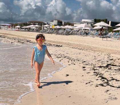 Alba da un paseo por la arena blanca de Costa Mujeres, en la península de Yucatán, ante la atenta mirada de sus padres