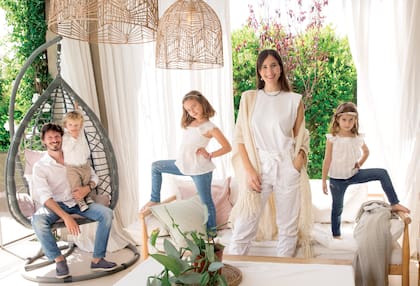 Agustina, su marido, Facundo Pelliza, y sus hijos, Josefina, Martina e Ignacio, posan sonrientes en la galería de su casa. 