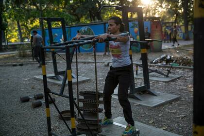 Aiken Pinero, de 27 años, levanta piezas de repuesto para automóviles y camiones en un gimnasio improvisado en el parque público Los Caobos en Caracas, Venezuela, el 26 de enero. Aiken dijo al Associated Press: "Dejé de ir a un gimnasio agradable porque ahora es caro para nosotros que sufrimos 