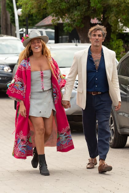 Ailin Bisi, con look folk (top, mini y tapado colorido) y Santiago Puoydebat.