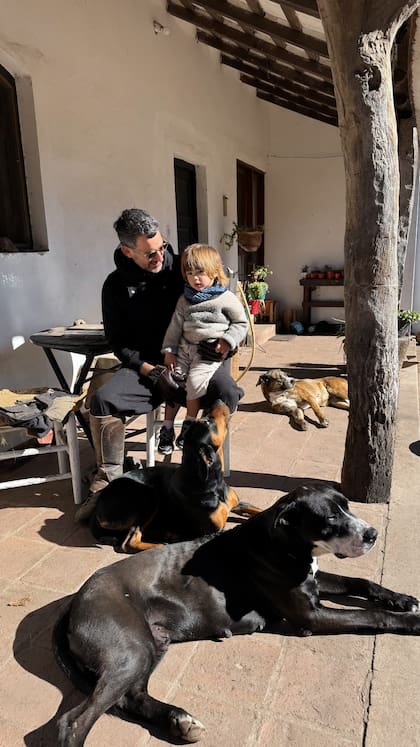 Aíto de la Rúa junto a su hijo Tao y varios perros, disfrutando del sol de invierno
