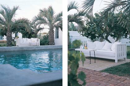 Al amparo de las palmeras, un sillón blanco de madera (Laura O.) y una mesita rectangular reciclada crean un rincón soñado para descansar.
