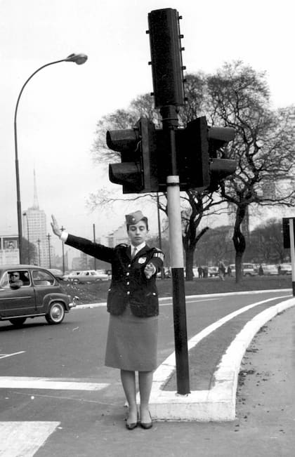 Al borde del obelisco, una de la inspectoras de tránsito colabora con señas para los peatones.