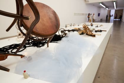 Al final de ocho metros de microcuentos, un hombrecito espera sentado en la tarima, en la galería Ruth Benzacar.