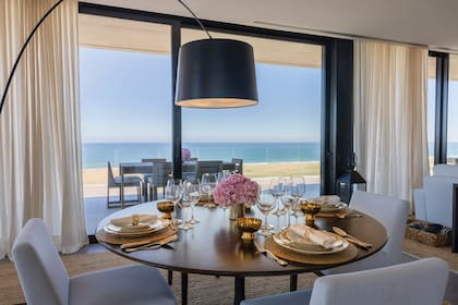 Al igual que el resto de los ambientes, el comedor fue decorado con simetría simple y sofisticada. “El diseño tenía que tener predominancia del blanco porque queríamos transmitir claridad. Nos gustaba la presencia de la madera para darle detalles playeros; el toque de elegancia lo dimos con las lámparas negras, entre otros objetos".