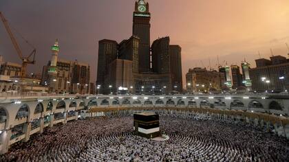 Vestidos de blanco, con las manos alzadas alcielo, los peregrino rezan en La Gran Mezquita