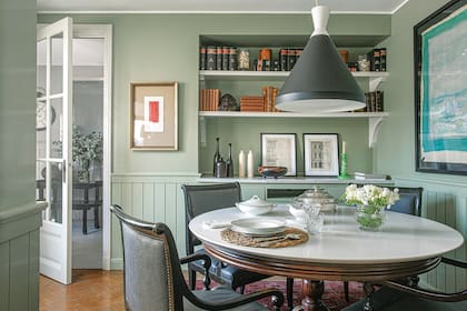 Al mueble de apoyo empotrado en la pared se le agregaron estantes para exhibir cuadros y libros antiguos.