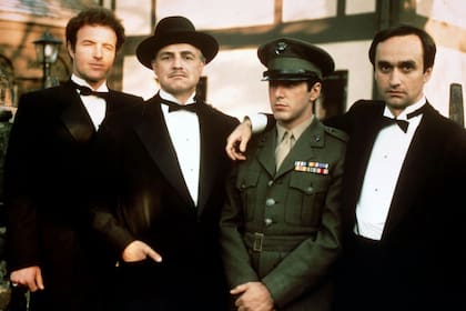 Al Pacino, de uniforme, durante una de sus primeras escenas en El Padrino. Junto a él, James Caan como Sonny Corleone, Marlon Brando como Vito Corleone, y John Cazale como Fredo Corleone