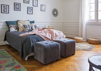 Al pie de la cama, pufs en pana gris (Mamani) y, en la zona de la ventana, una versión en seagrass, igual que la alfombra (Fraternidad).