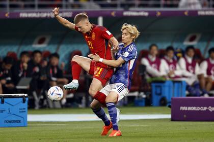 El español Daniel Olmo protege la pelota ante la marca de Junya Ito, de Japón, durante el partido del Grupo E de Qatar 2022