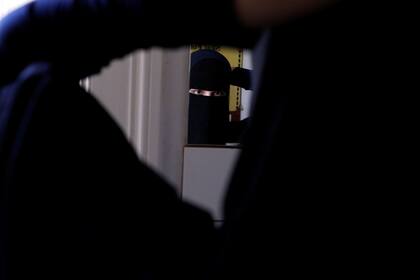 Alaa de 21 años, miembro del grupo Kvinder I Dialog (Mujeres en diálogo), se arregla su niqab en un espejo en Copenhague