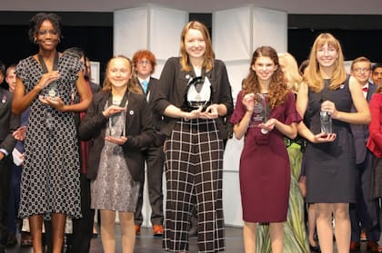 Alaina Gassler (centro) con su premio por el sistema para evitar el punto ciego y mejorar la seguiridad vehicular