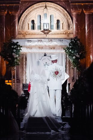 Alan coordinó cromáticamente su look con el de su novia: llevó un saco con detalle de un corazón y flechas que lo atraviesan en la espalda, camisa, pantalón decorado con línea dorada en los laterales confeccionados por su sastre personal. Lo acompañó con una galera.