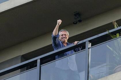 Alberto Fernández saluda desde el balcón de su departamento en el barrio porteño de Puerto Madero, tras el anuncio de Cristina de su candidatura presidencial, el 15 de mayo de 2019