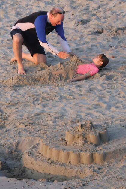 Alberto de Mónaco le hace un traje de sirena a Gabriella con arena húmeda, muy cerca del castillo que los mellizos levantaron en la playa. Entre los tres y con ayuda de un guardaespaldas, descargaron en la playa bolsos con toallones, snacks y juguetes.
