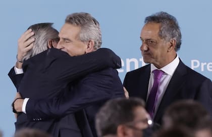 Alberto Fernández abraza a Agustín Rossi en el acto de jura como jefe de la AFI, en pleno escándalo del avión venezolano; los mira Scioli, nuevo ministro de Desarrollo Productivo