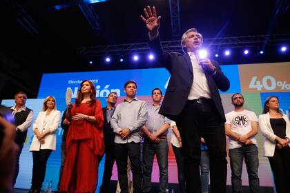 Alberto Fernández da su discurso en el búnker. Detrás, Cristina Kirchner y Axel Kicillof