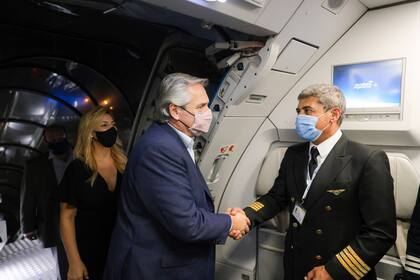 Alberto Fernández, en el avión a punto de partir a Roma; en segundo plano, su pareja, Fabiola Yañez