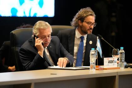 Alberto Fernández habla por teléfono junto a Santiago Cafiero durante la cumbre del Mercosur 