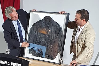 Alberto Fernández recibe la campera de Saúl Ubaldini de manos de su hijo; un regalo que pondrá cerca de sus cuadros de Raúl Alfonsín