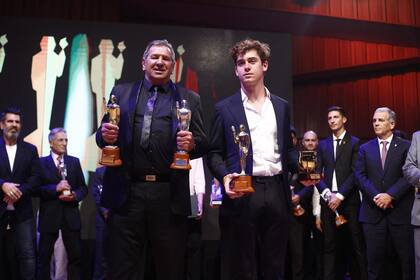 Alberto Martínez, el papá de Dibu, y Franco Colapinto sostienen las estatuillas Olimpia de Oro que fueron otorgadas por el Círculo de Periodistas Deportivos en La Usina del Arte.