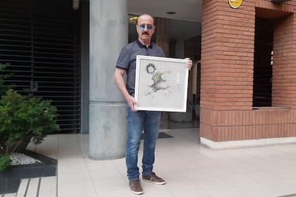 Aldo Pedro Poy con un dibujo de puño y letra del Negro Fontanarrosa.